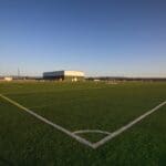 A soccer field with the corner of a goal.