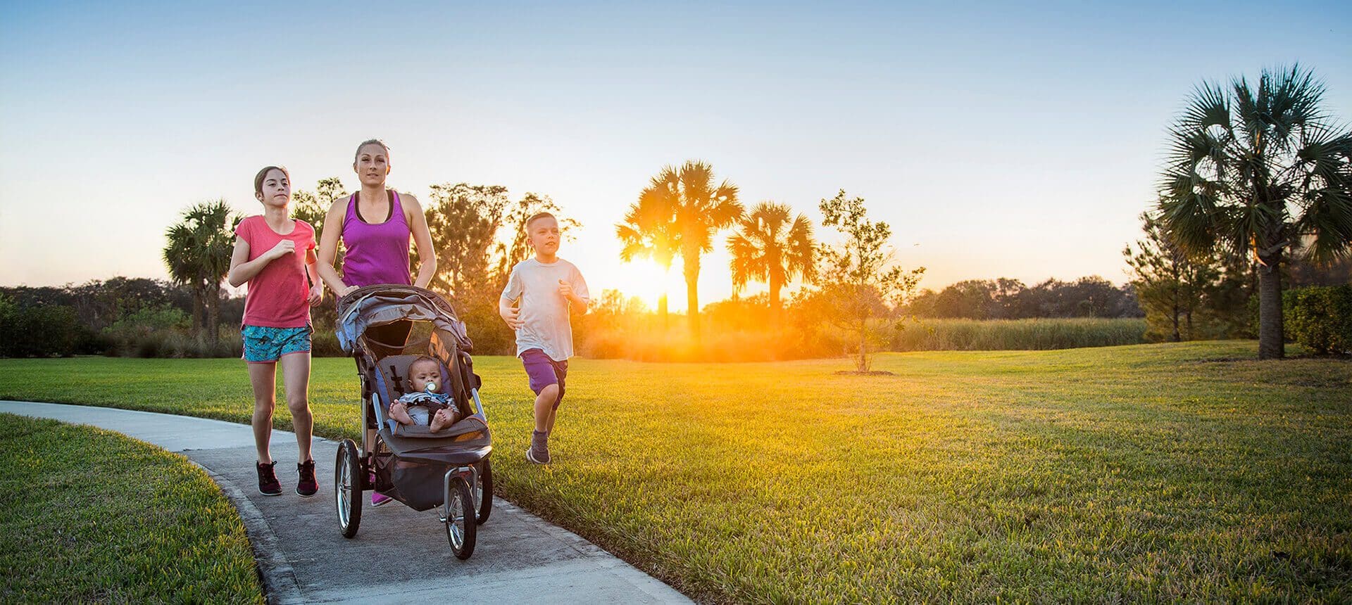 A woman and child running in the park