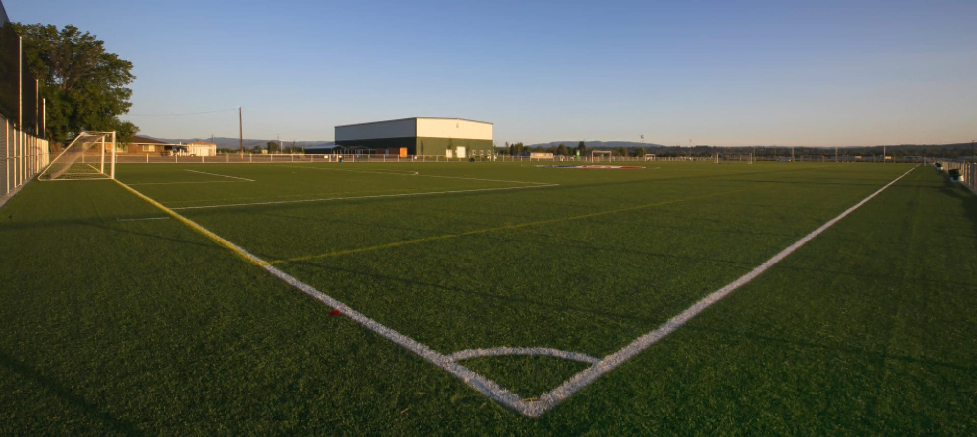 A soccer field with a white line on the corner.