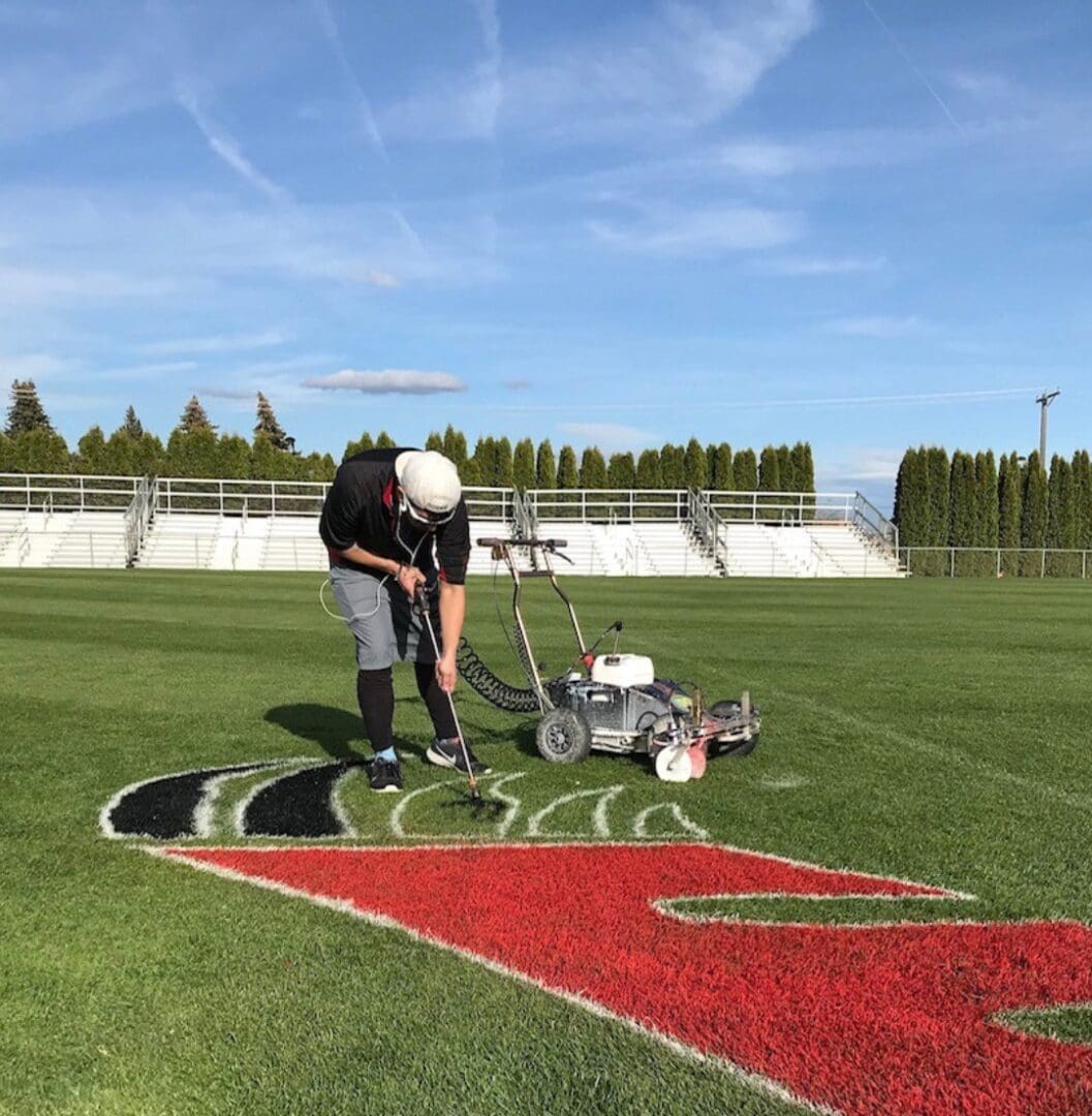 A man is using a ground marker to mark the field.