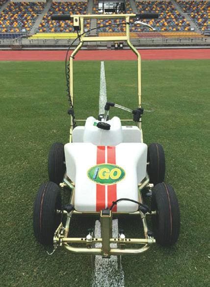 A lawn mower sitting on top of a green field.