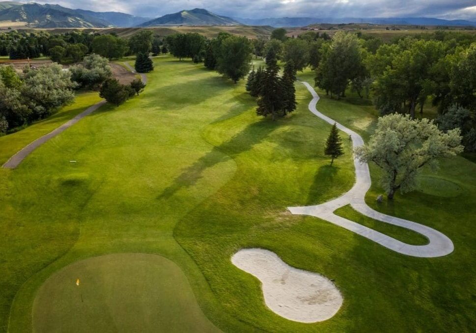 A golf course with many trees and a path